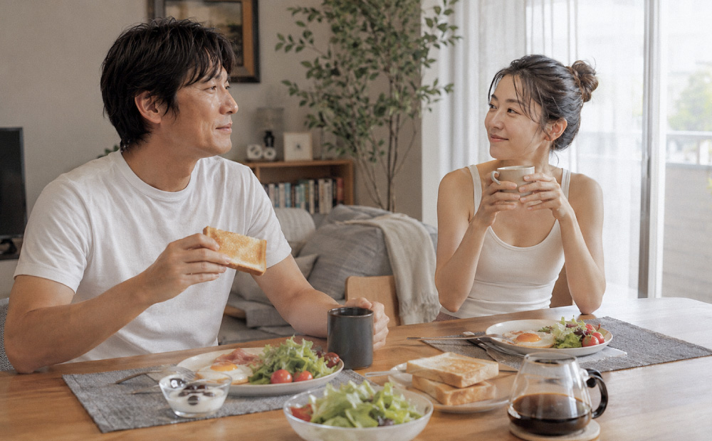 スキンケアが終わり朝食を食べる男女